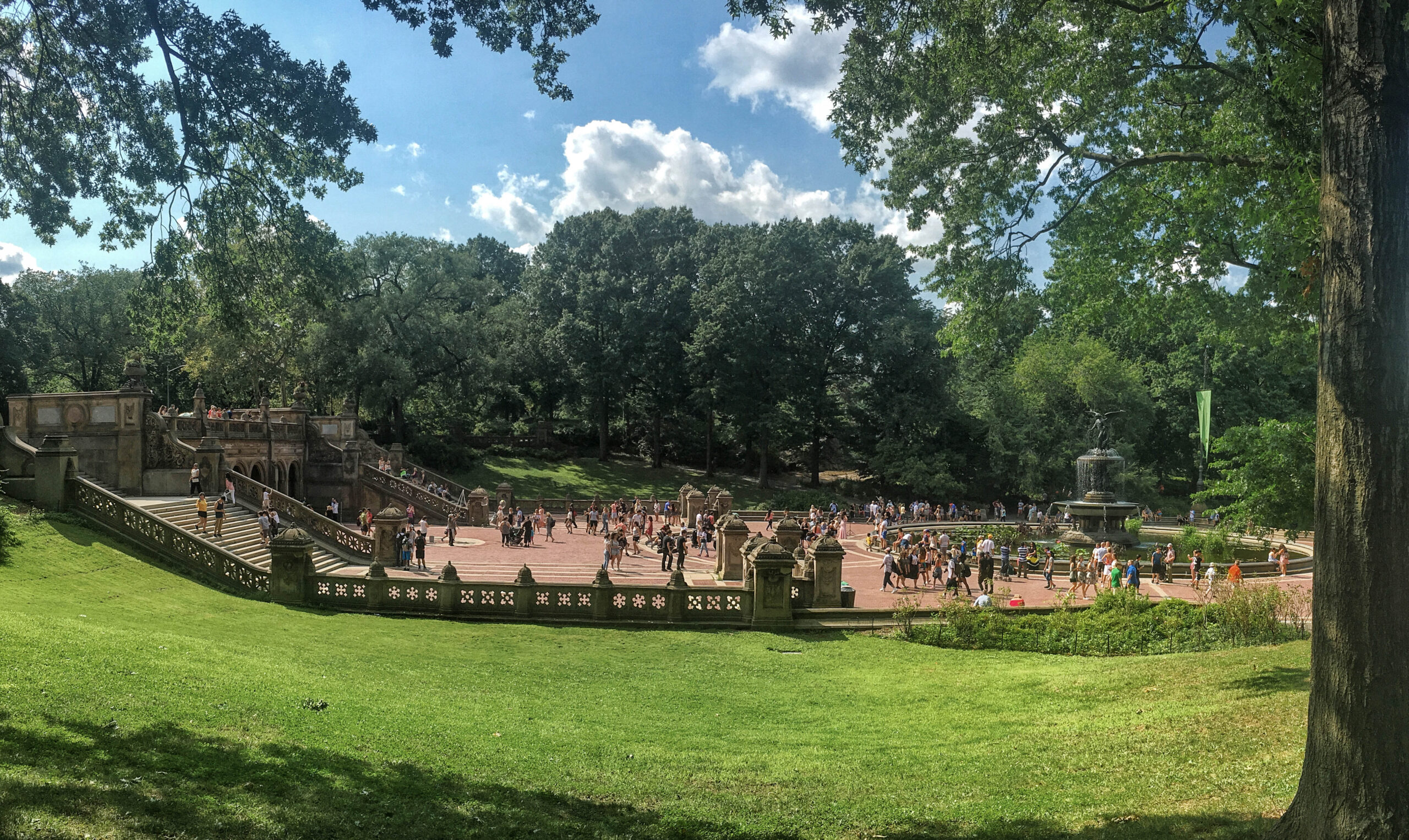 Square with a fountain in the middle of a green park in summer