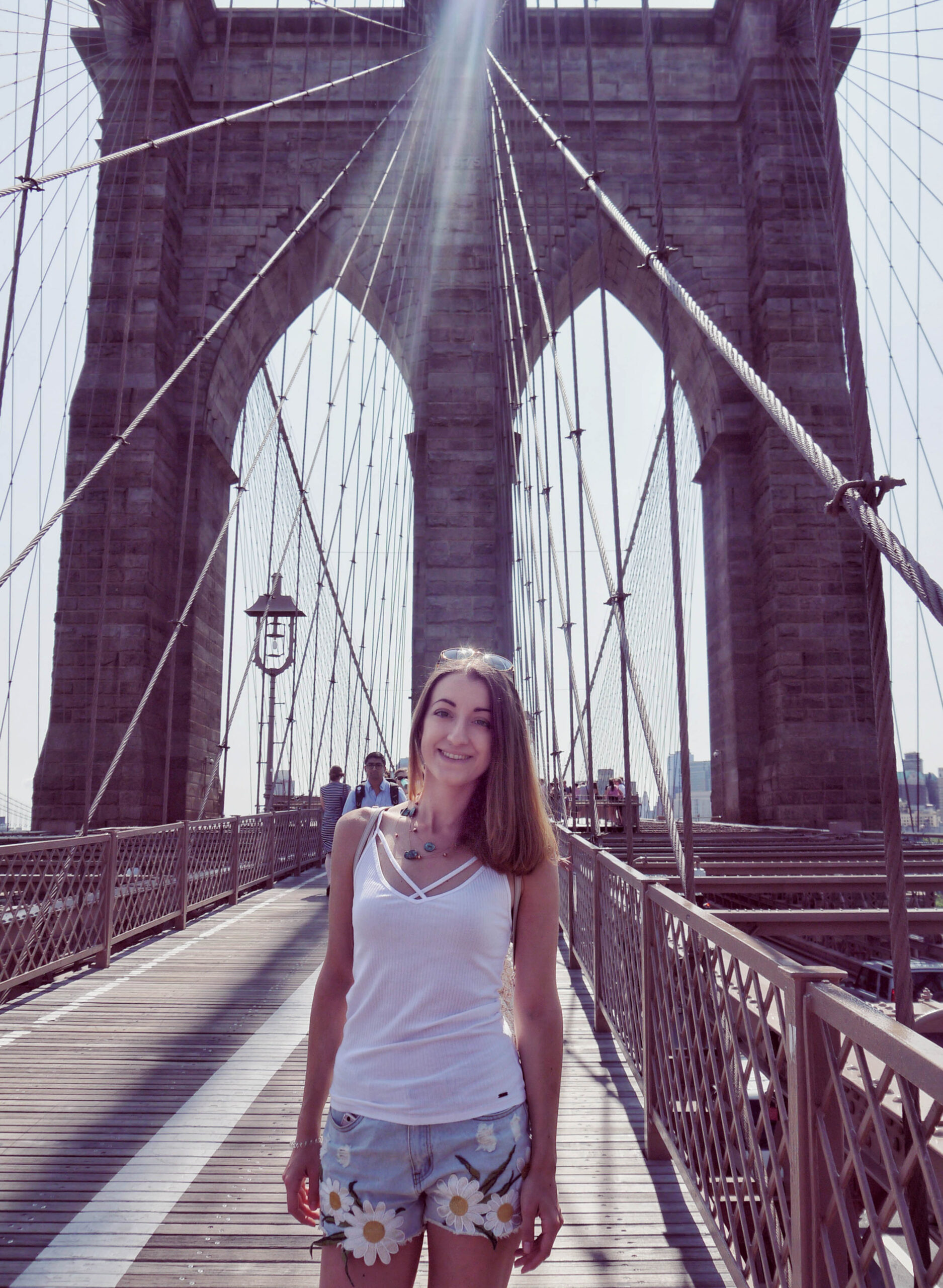 Girl against the arches of the Brooklyn Bridge in summer