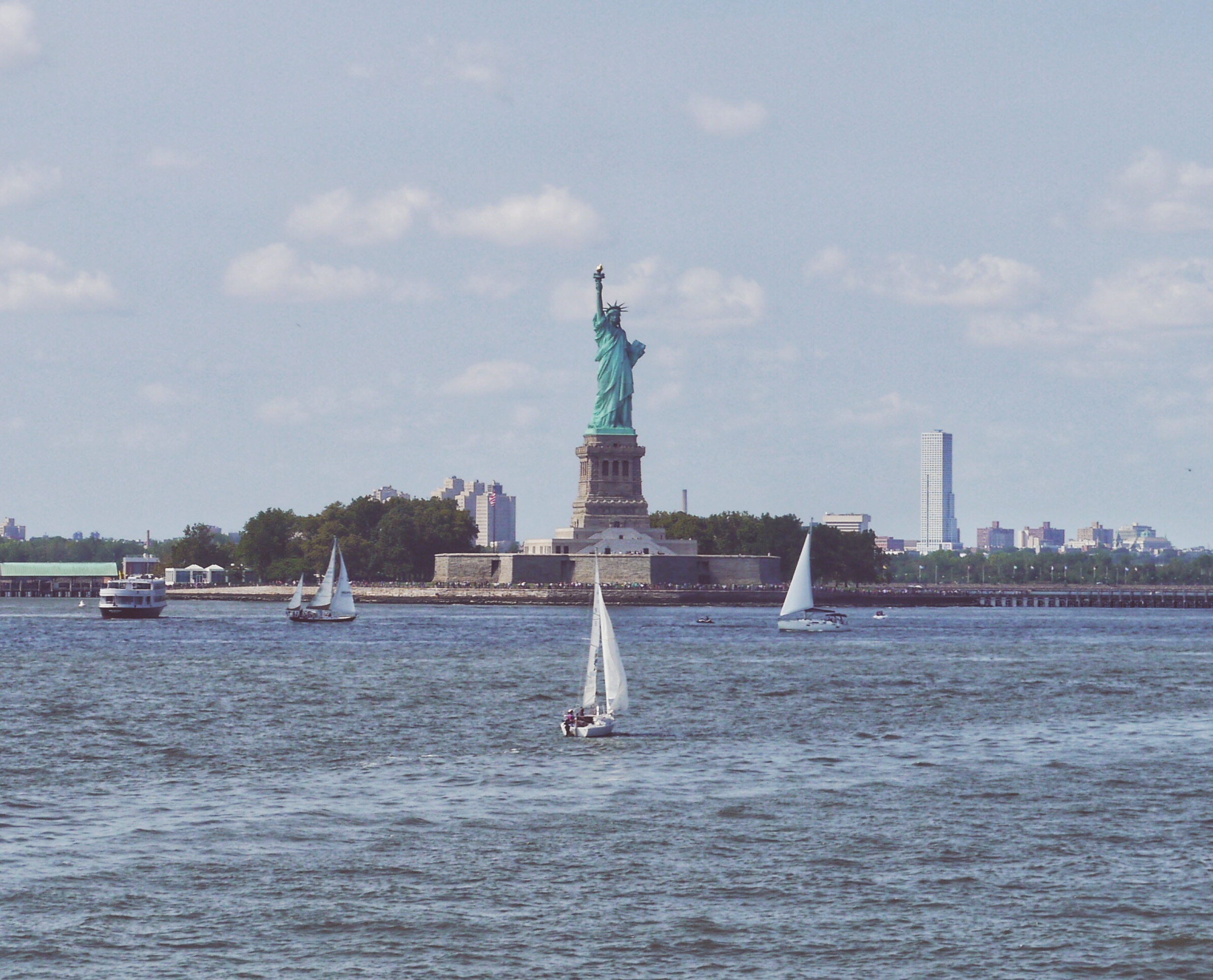 The Status of Liberty from the water and some small boats