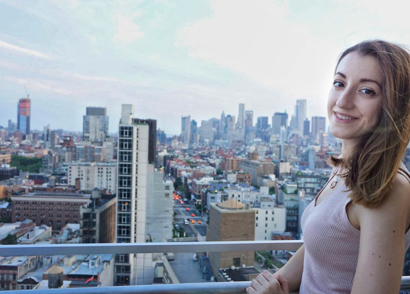 Best of New York - Smiling girl on a terrace with a view of the Manhattan skyline