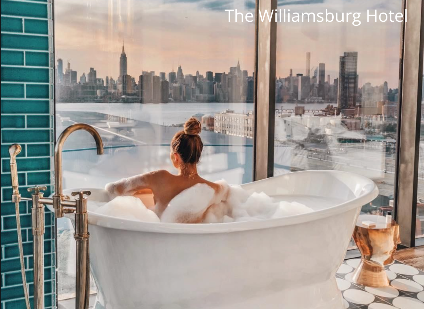 Woman in hotel bath tub looking out on the New York city skyline