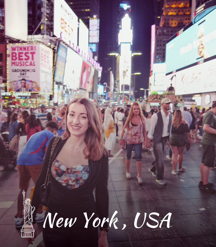 Home - smiling girl in Times Square at night