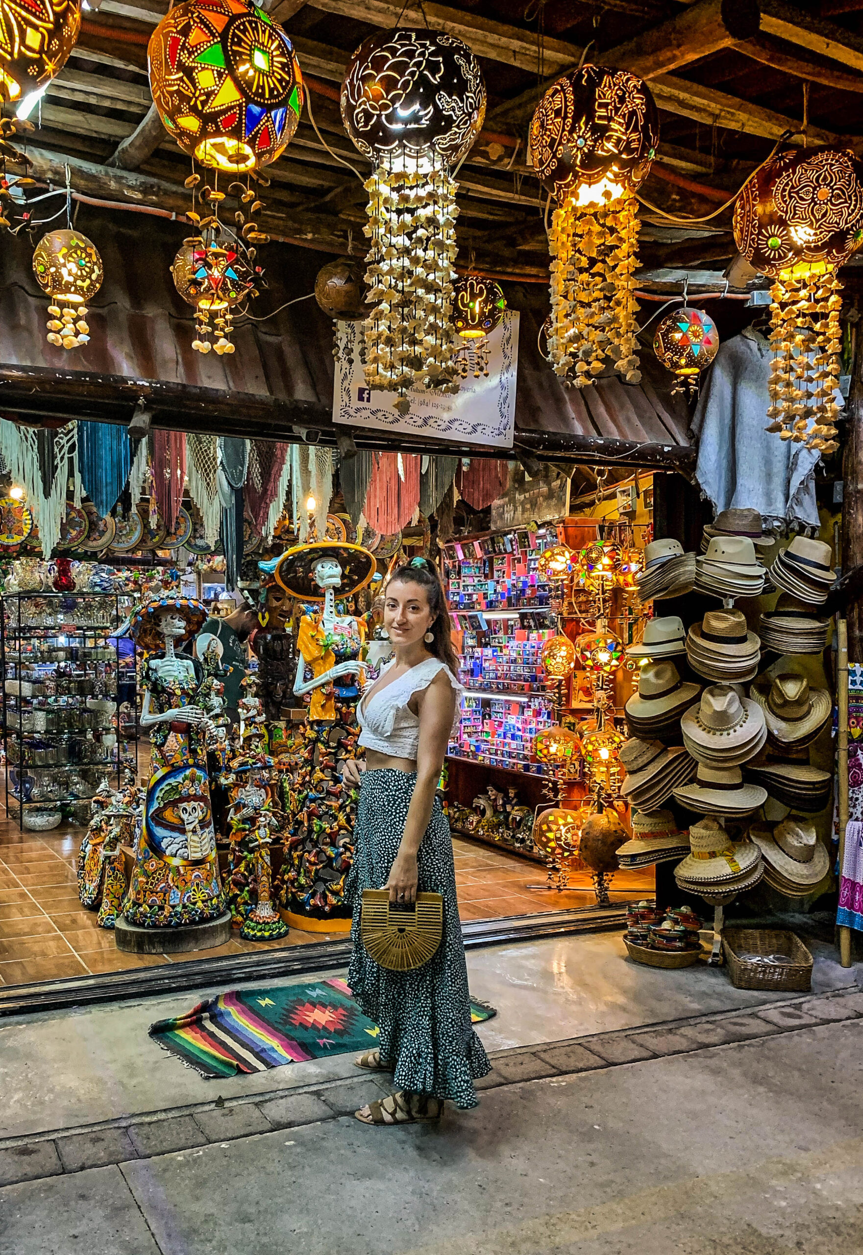 Girl in from of souvenir shop ifull of lights and small gifts Tulum town