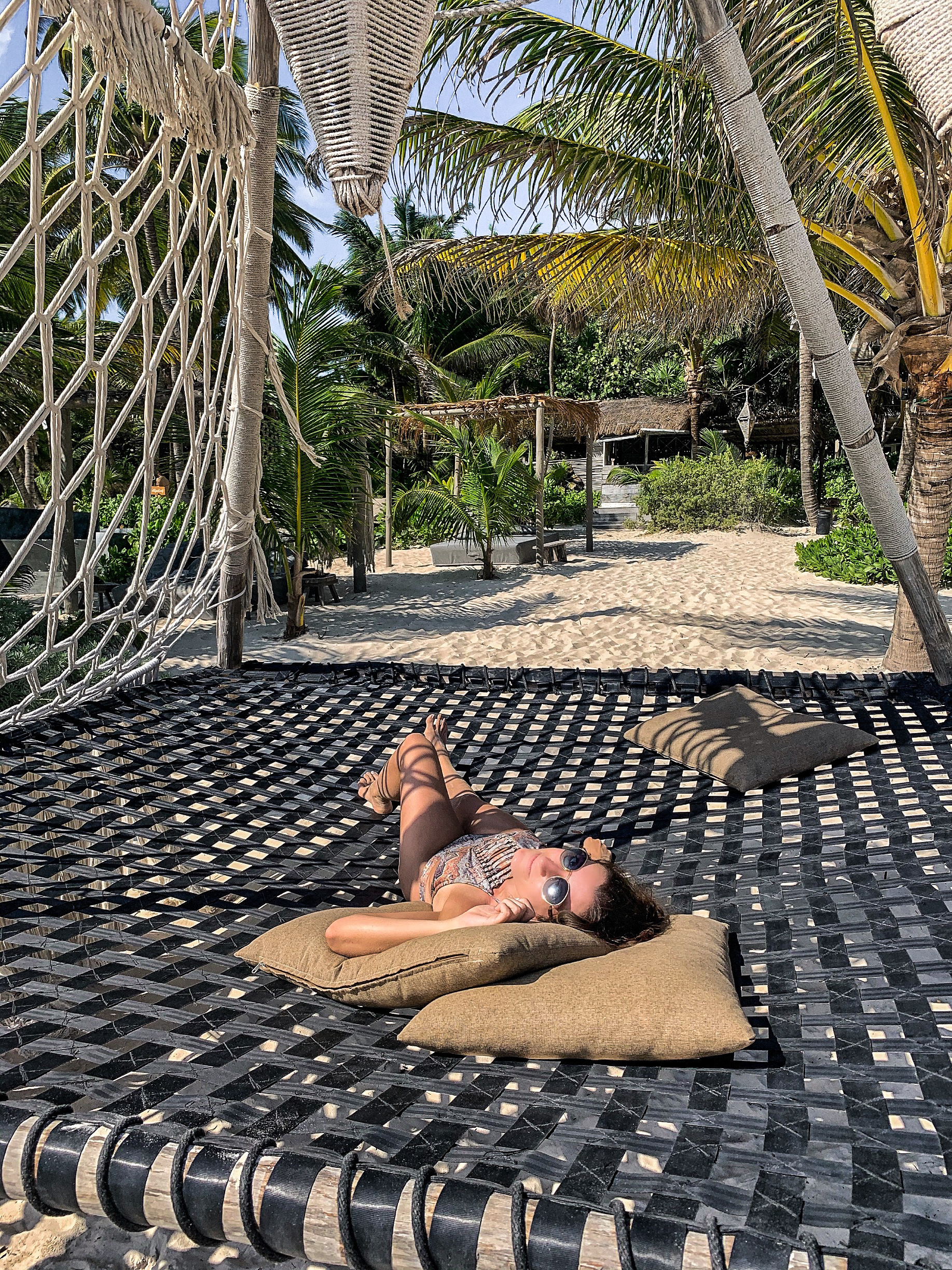 Girl lying on huge hammock bed on the beach Nomade